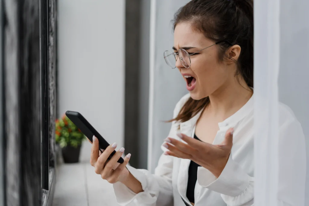 Mobile user experience tips image representing a young woman being frustrated over slow mobile phone.